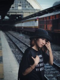 Thoughtful woman standing on railroad station platform
