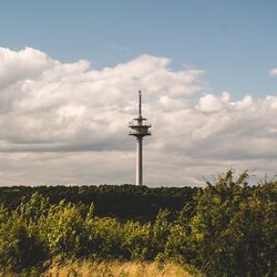 View of communications tower against cloudy sky