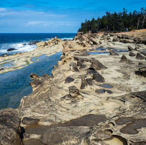 Scenic view of rocks on beach against sky