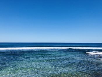 Scenic view of sea against clear blue sky