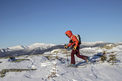 Backcountry skier skins across summit of baldface, nh mount washington