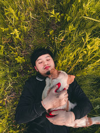 Young man with dog against plants