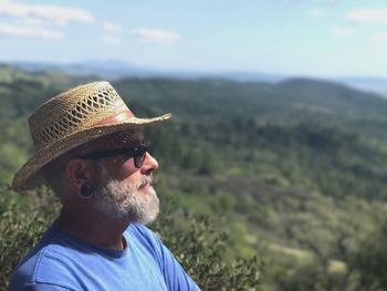 Bearded man wearing hat against landscape