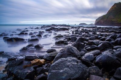 Rocky coastline against cloudy sky