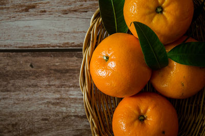 High angle view of orange fruits in basket on table