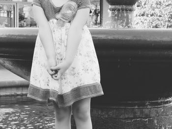 Midsection of woman standing by water