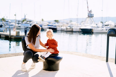 Rear view of women sitting on boat in water