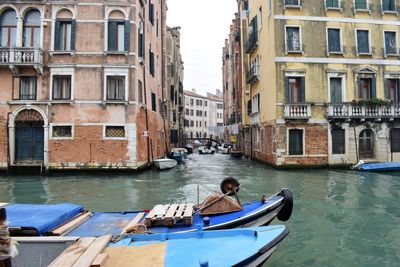 Boats in canal amidst buildings in city