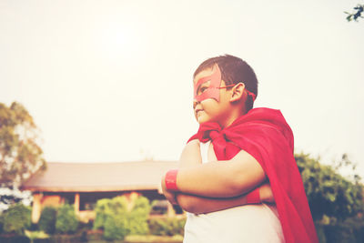 Boy with cape and eye patch playing in park