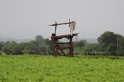 Traditional windmill on field against clear sky