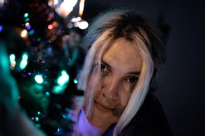 Portrait of woman by christmas tree