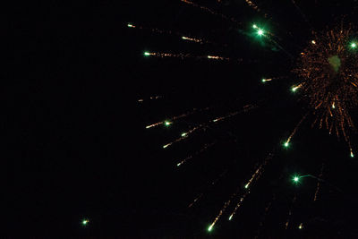 Low angle view of fireworks against sky at night
