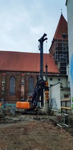 Construction site by building against sky