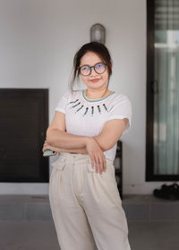 Portrait of woman standing against wall