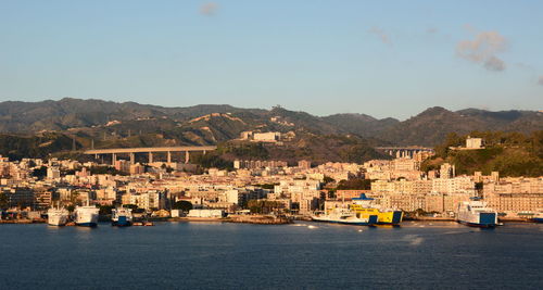 Buildings by river against sky