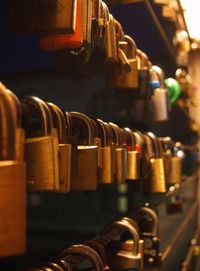 Lined-up padlocks on a bridge by night