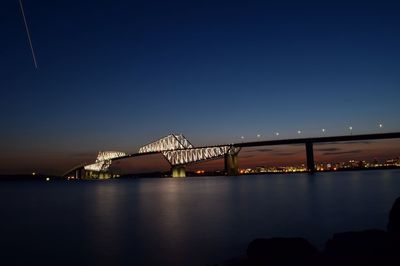 Silhouette bridge against sky at night