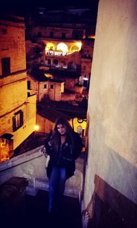 Portrait of young woman standing in illuminated building