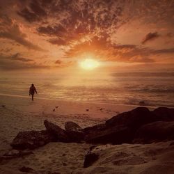 Silhouette of people on beach at sunset