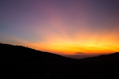Scenic view of silhouette mountains against sky during sunset