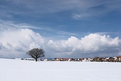 Scenic view of snow covered field against sky