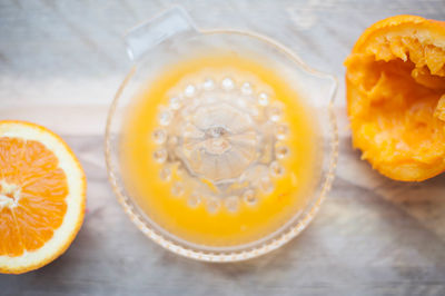 Close-up of oranges with juicer on table
