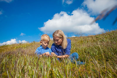 Full length of father and daughter on field against sky