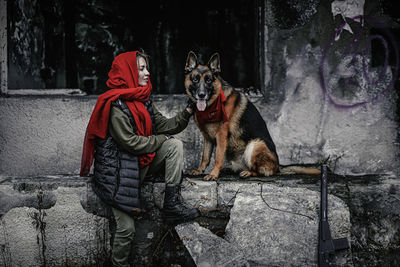 Dog sitting on floor against wall