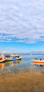 Boats moored in sea against sky