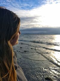 Woman looking at sea against sky