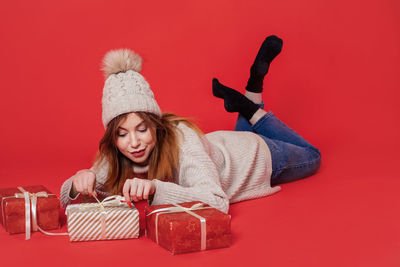 Portrait of smiling young woman against red background