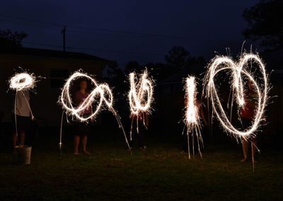 Illuminated firework display at night