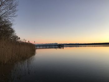 Scenic view of lake against clear sky during sunset