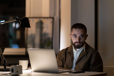 Overwork before project deadline, casual man programmer or web developer staying late in office