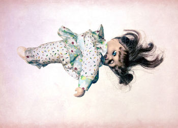 High angle portrait of young woman lying on white background