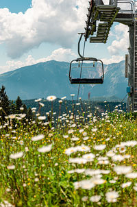 Chair lift over mountains against sky