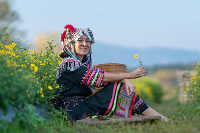 Portrait of woman holding umbrella while standing on field