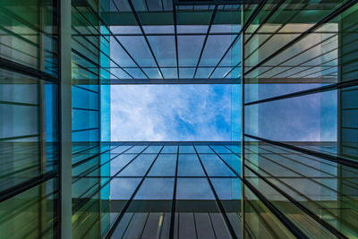 Low angle view of glass building against sky