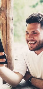 Happy young man looking at mobile phone