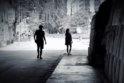 Silhouette people walking on street in city