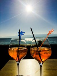 Wineglass on table against sky on sunny day