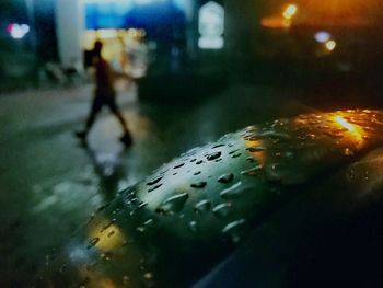 Close-up of wet illuminated street at night