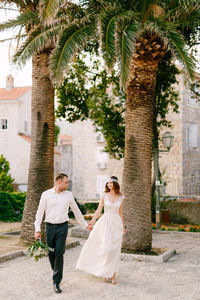 Couple walking in front of palm trees