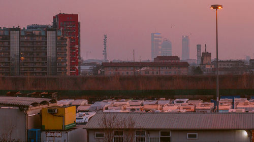 Buildings in city against clear sky during sunset