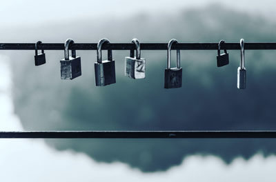 Close-up of padlocks hanging on railing