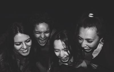 Happy friends looking down in darkroom