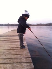 Woman standing on pier at lake