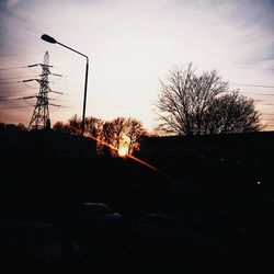 Silhouette of electricity pylon at sunset