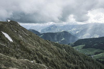 Scenic view of mountains against cloudy sky