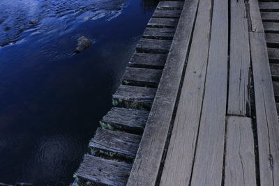 High angle view of bird on pier over lake